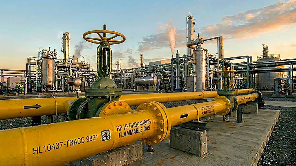 Clean parallel yellow hydrocarbon pipeline manifold inside an oil refinery, demonstrating the final stage of counterfeit PVF material mitigation.